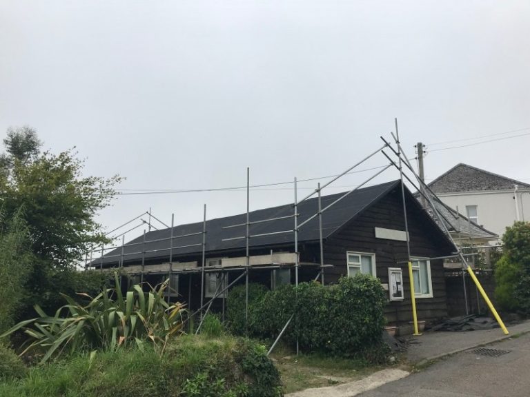 Single story building with scaffolding in place for roof replacement